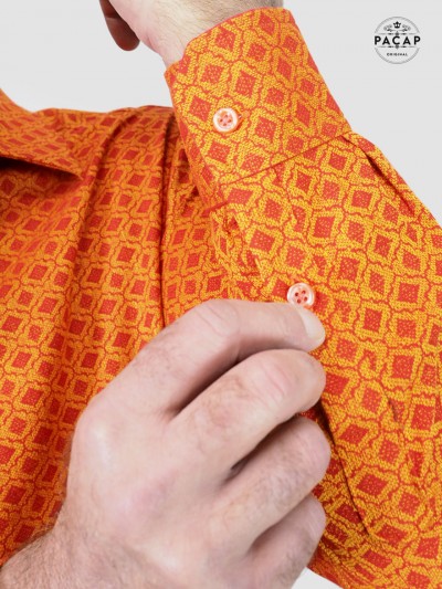 orange shirt with embroidered knit pattern and long buttoned sleeve