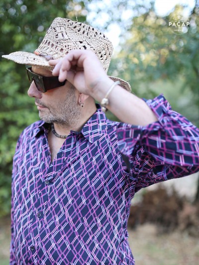 man with straw hat, sunglasses and purple fantasy print shirt