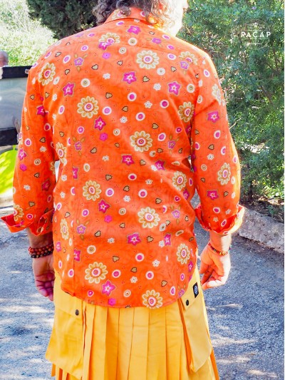 homme avec kilt jaune et chemise orange à fleurs look flashy décontractée