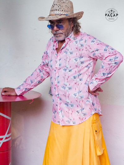 homme en kilt jaune unicolore et chemise rose a fleurs de pavot champ de coquelicot, poinceau et lunette de soleil